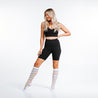 Marathon knee high compression socks with brightly colored stripes in blue, purple, pink ,and yellow - on model