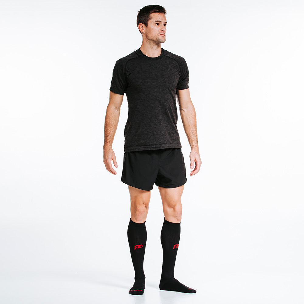 PRO Compression Marathon socks for running and recovery close up of man wearing black knee-high sock